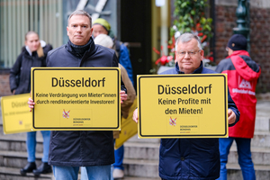 Foto: Michael Gstettenbauer Auf den beiden Fotos sieht man Hans-Jochem Witzke (1.Vorsitzender) und Claus Nesemann (Geschäftsführer) wie sie vor dem Düsseldorfer Rathaus Schilder mit den Aufschriften „Düsseldorf Keine Profite mit den Mieten!“ und „Düsseldorf Keine Verdrängung von Mieter*innen durch renditeorientierte Investoren“ hochhalten. Außerdem werden Bündnismitglieder gezeigt, wie sie ein Transparent mit dem Logo und dem Namen des Bündnisses hochhalten.