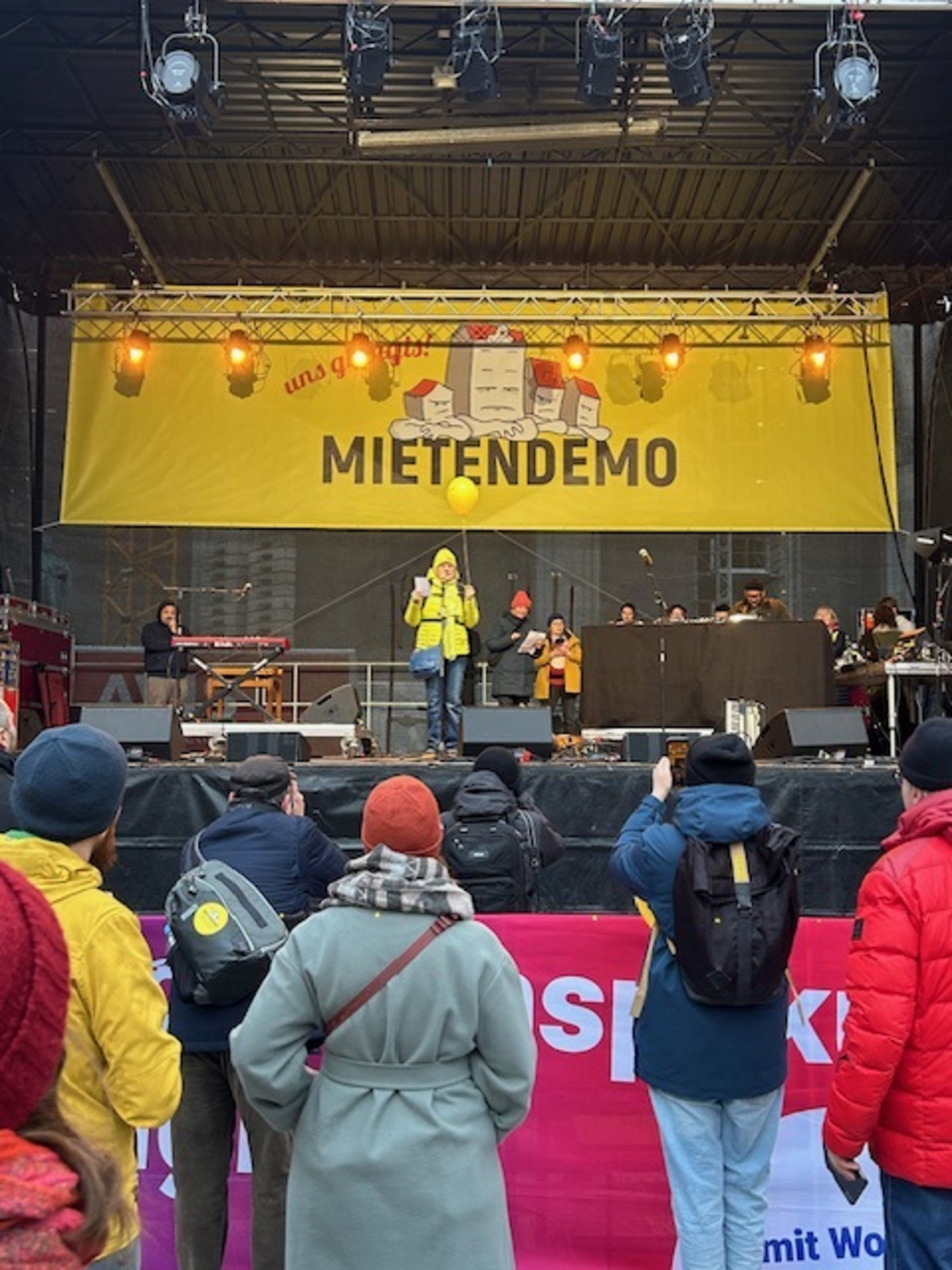Die Fotos zeigen Teilnehmerinnen und Teilnehmer der Mieten-Demo in München. Man sieht, wie die Demonstrierenden auf der Straße unterwegs sind und Fahnen und Transparente hochhalten.