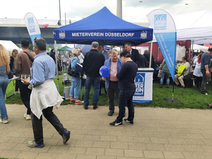 Die Fotos zeigen den Stand (Pavillon), den der Mieterverein Düsseldorf für den 1. Mai aufgebaut hat. Auf den Fotos sind Menschen zu sehen, die sich Informationen zum Mietrecht und zur Wohnungspolitik geben lassen. Außerdem sind auf den Fotos Hans-Jochem Witzke (1. Vorsitzender), Claus Nesemann(Geschäftsführer) und Sigrid Wolf (DGB Düsseldorf) zu sehen.