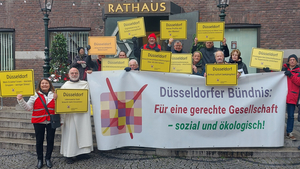 Foto: Michael Gstettenbauer Auf den beiden Fotos sieht man Hans-Jochem Witzke (1.Vorsitzender) und Claus Nesemann (Geschäftsführer) wie sie vor dem Düsseldorfer Rathaus Schilder mit den Aufschriften „Düsseldorf Keine Profite mit den Mieten!“ und „Düsseldorf Keine Verdrängung von Mieter*innen durch renditeorientierte Investoren“ hochhalten. Außerdem werden Bündnismitglieder gezeigt, wie sie ein Transparent mit dem Logo und dem Namen des Bündnisses hochhalten.