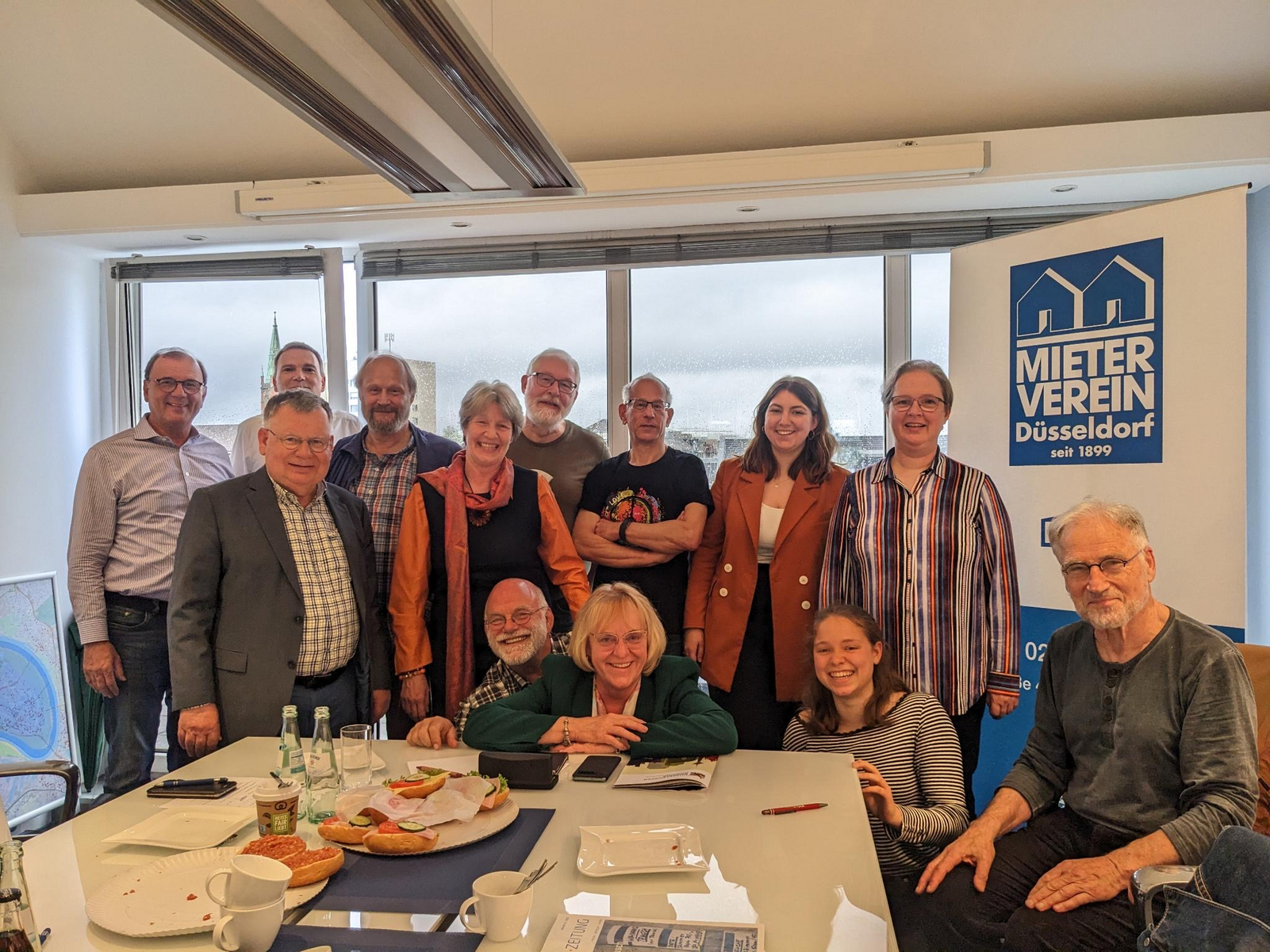 Das Foto zeigt 13 Mitglieder des Bündnisses, die sich im Sitzungssaal des Mietervereins getroffen und sich für das Foto zusammen aufgestellt haben.